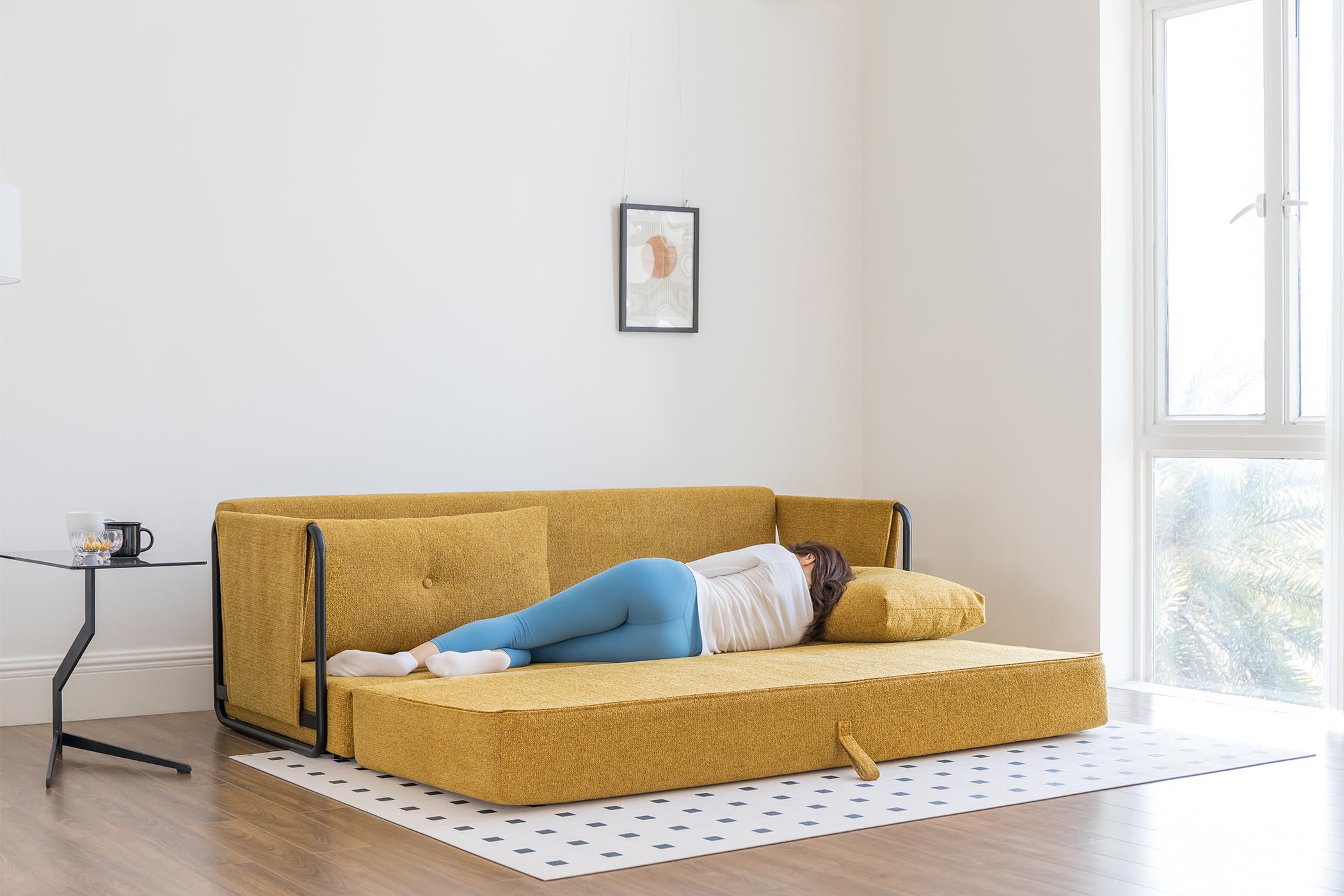 model sleeping on sofa bed in living room scene