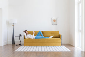 model lying on sofa bed in living room scene