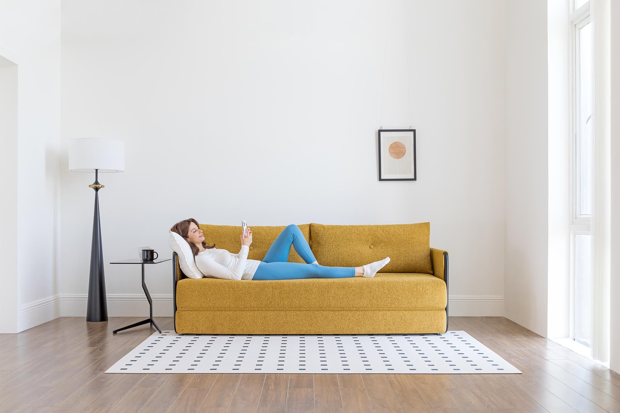 model lying on sofa bed in living room scene