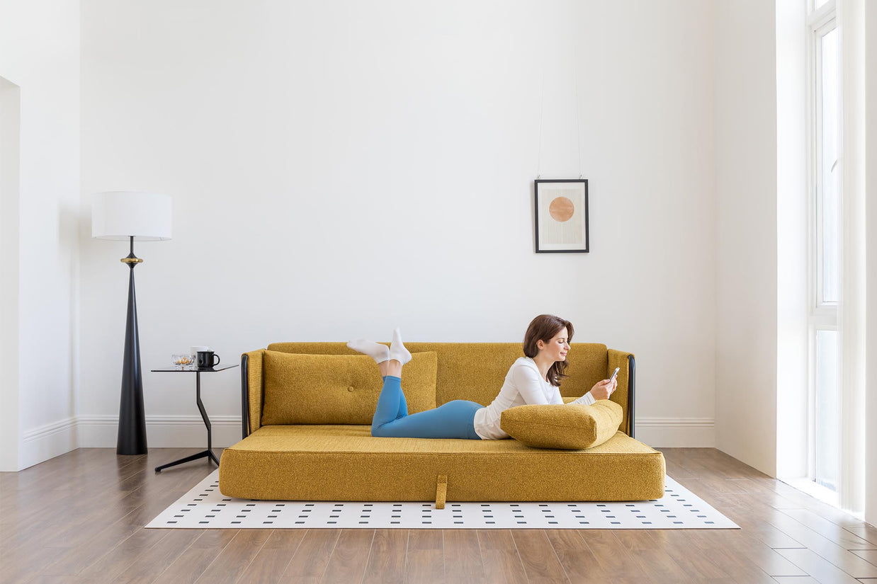model lying on sofa bed in living room scene