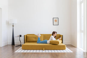 model lying on sofa bed in living room scene