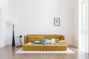 model sleeping on sofa bed in living room scene