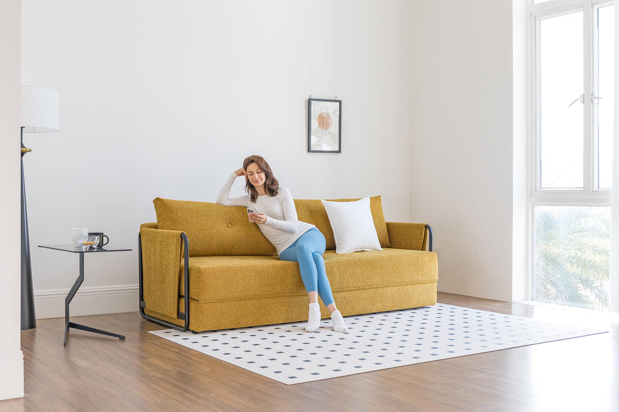 model sitting on sofa bed in living room scene
