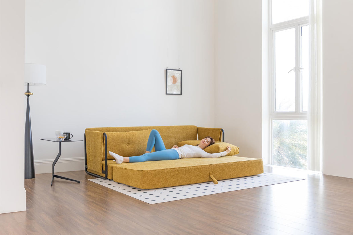 model sleeping on sofa bed in living room scene