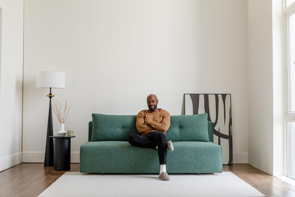 model sitting on sofa bed in living room scene
