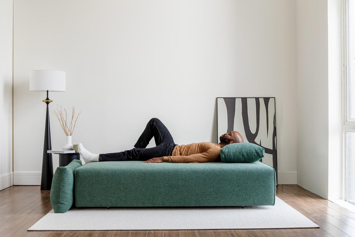 model sleeping on sofa bed in living room scene