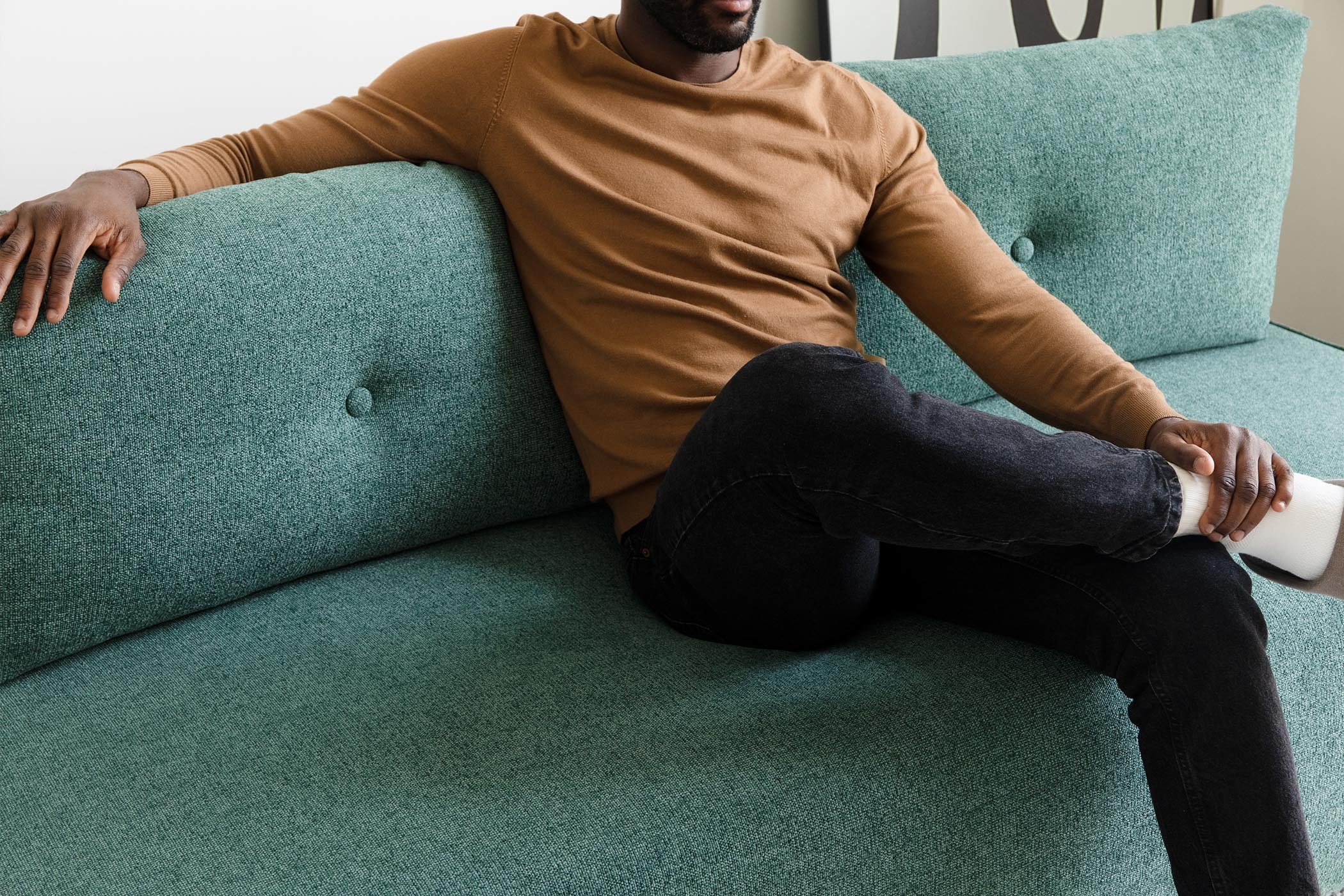 detail of model sitting on sofa bed