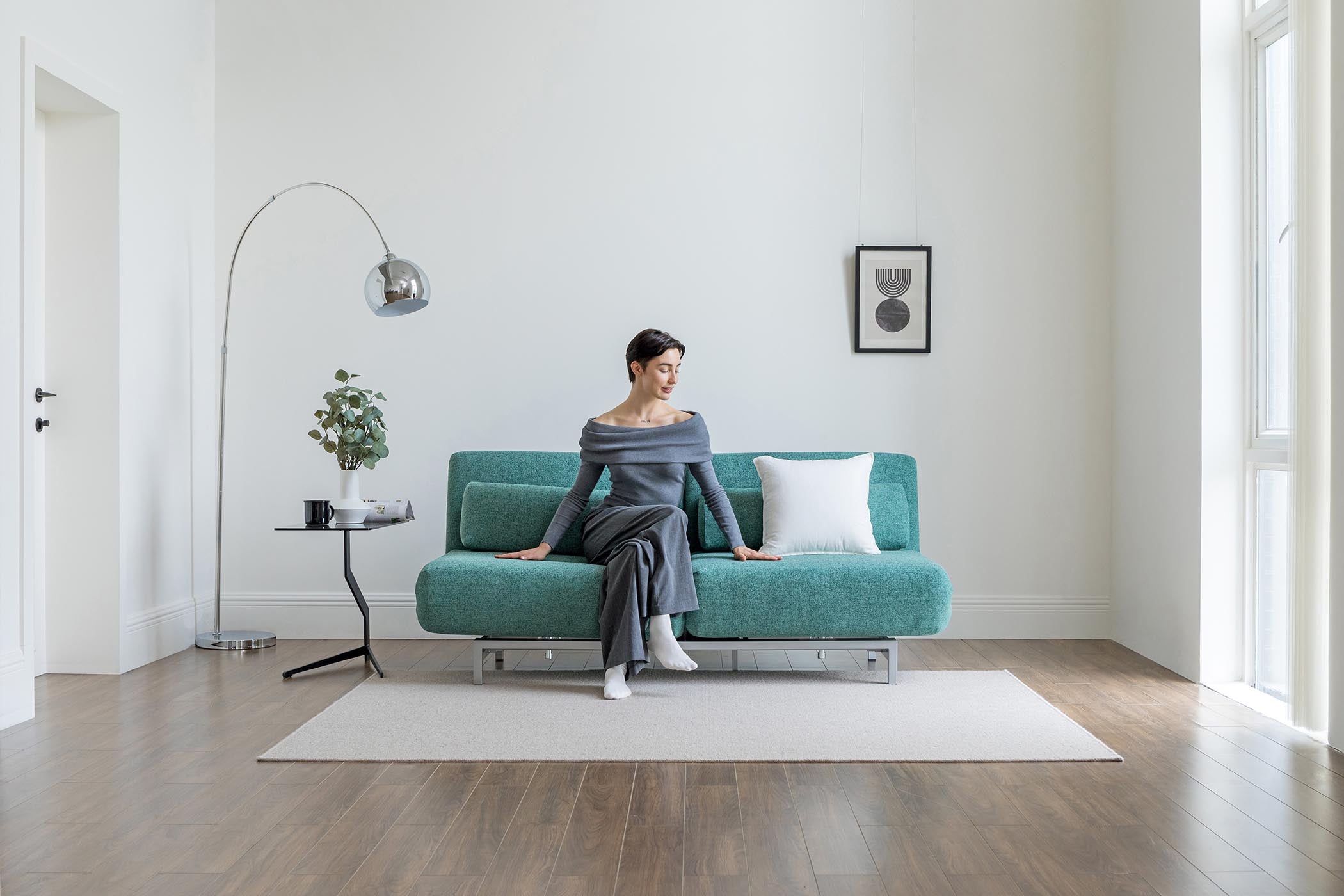 model sitting on sofa bed in living room scene