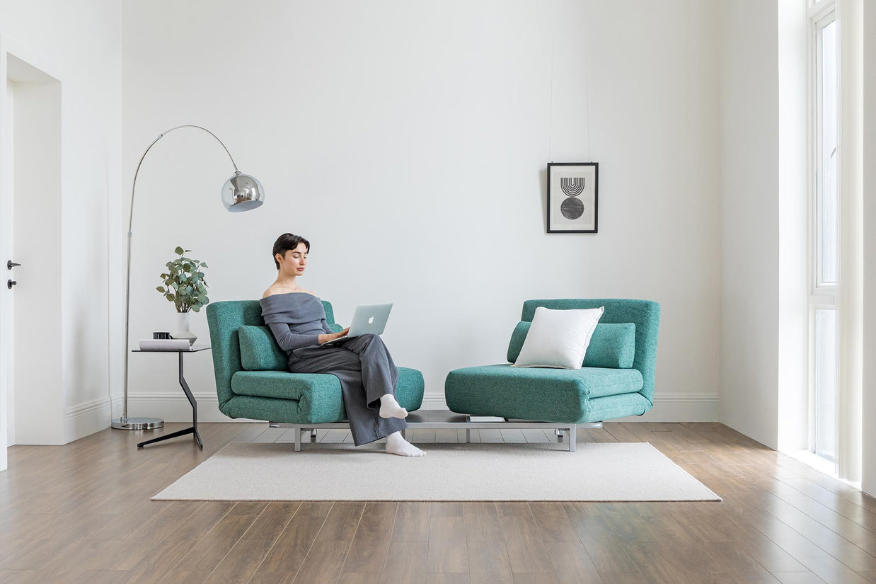 model sitting on the turning sofa bed in living room scene