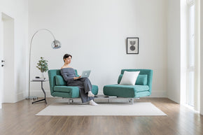 model sitting on the turning sofa bed in living room scene