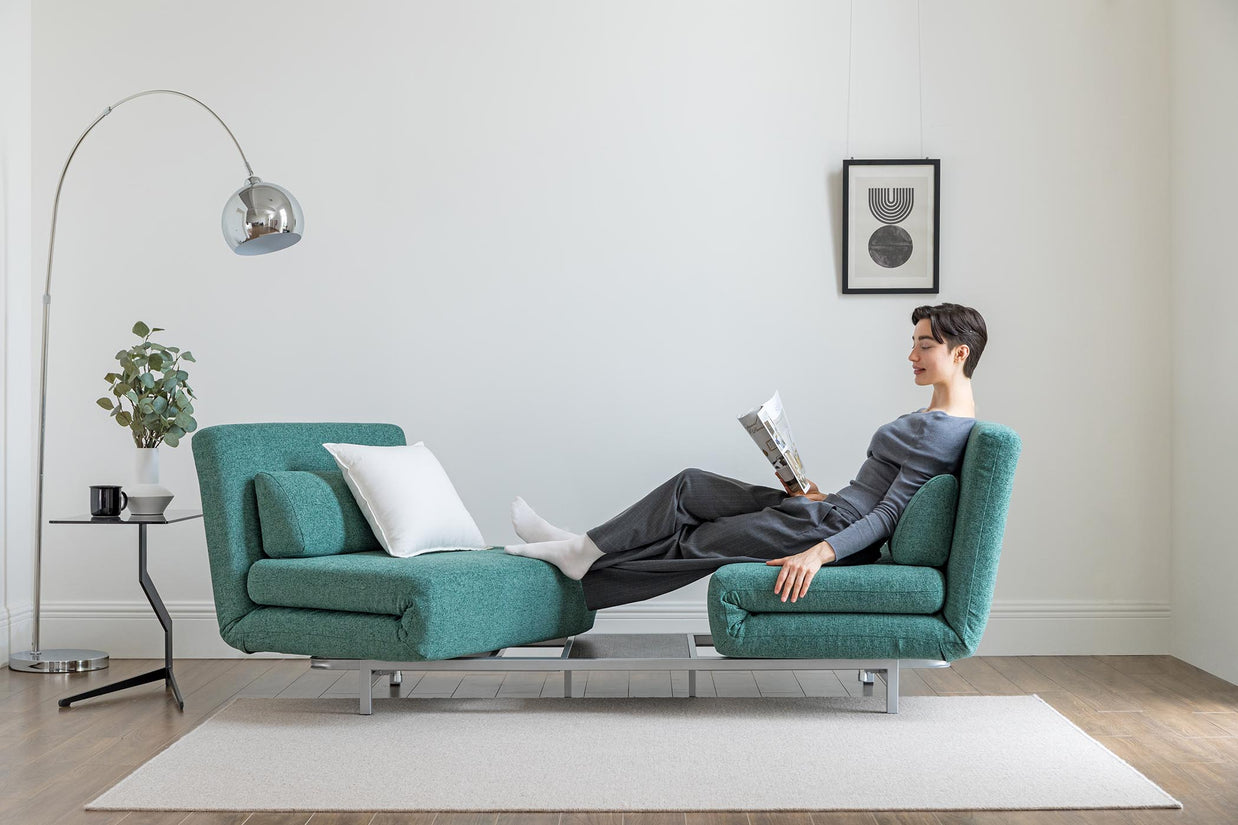model sitting on the turning sofa bed in living room scene