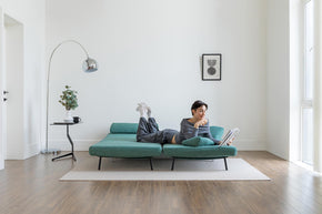 model lying on sofa bed in living room scene