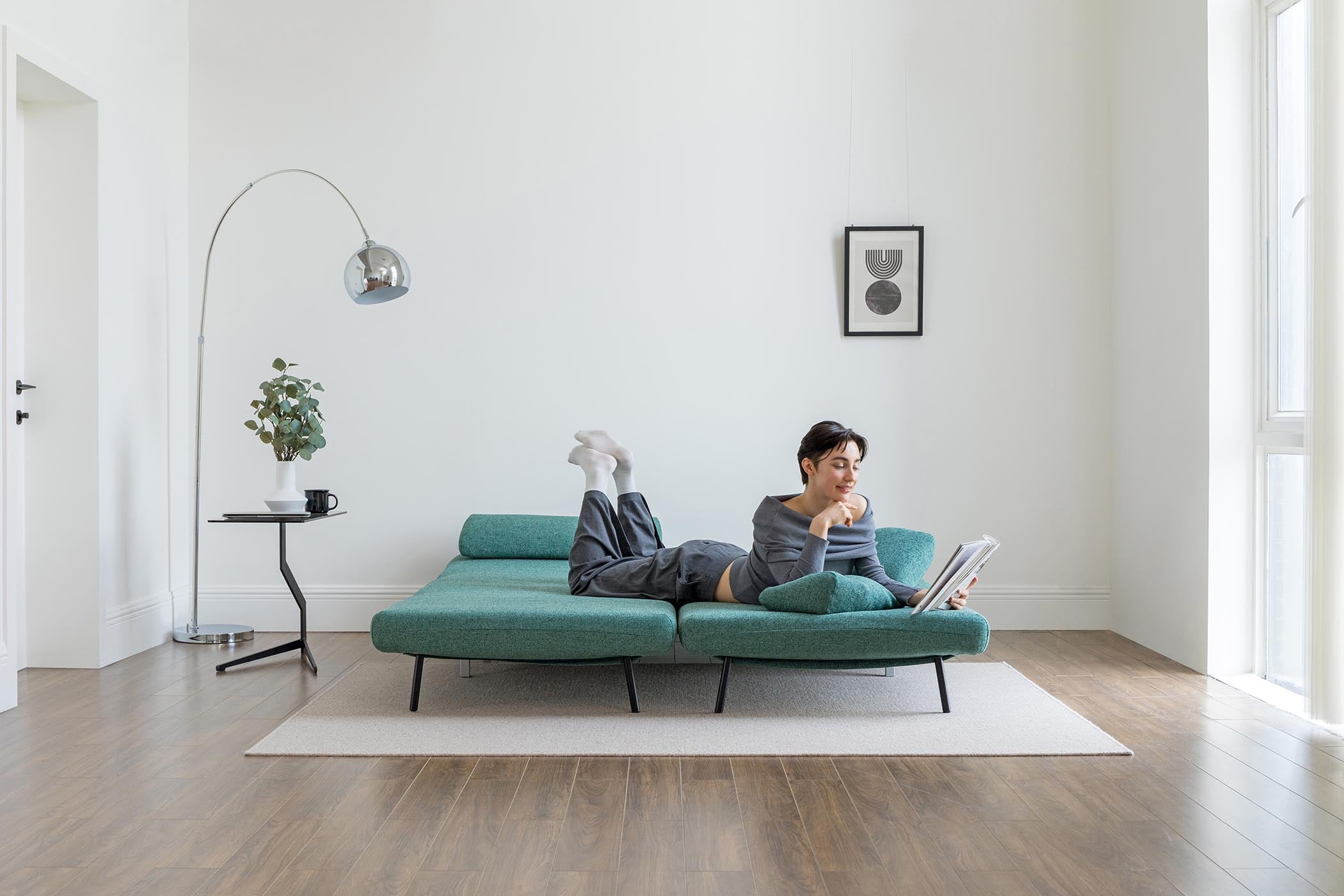 model lying on sofa bed in living room scene