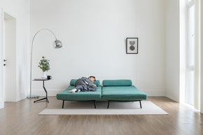 model sleeping on sofa bed in living room scene