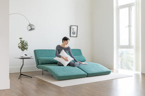 model sitting on sofa bed in lounge mode in living room scene