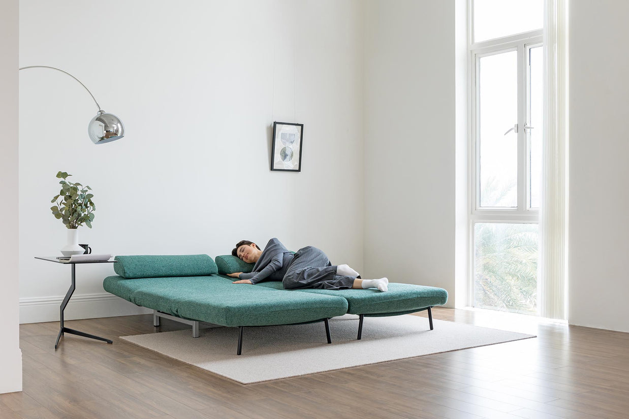 model sleeping on sofa bed in living room scene