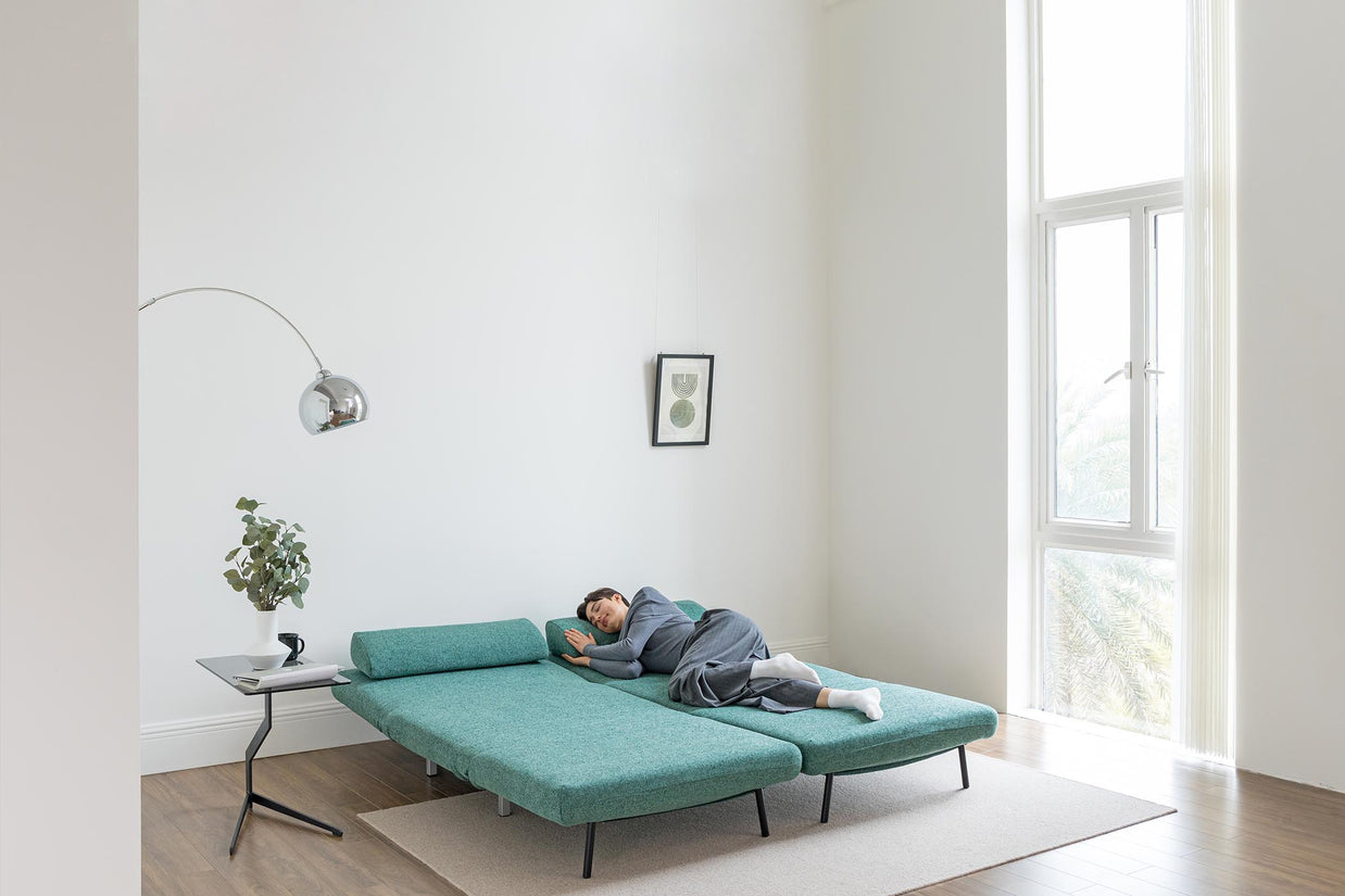 model sleeping on sofa bed in living room scene
