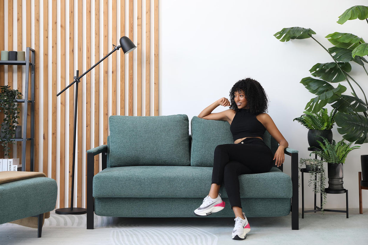 model sitting on sofa bed in living room
